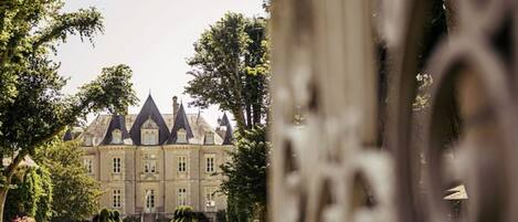 A grand chateau with a symmetrical facade, a central entrance, and a well-maintained garden.