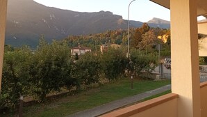 Un balcon donnant sur un paysage montagneux, un lampadaire et un bâtiment en arrière-plan.