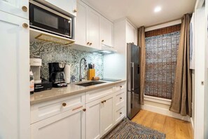 Fridge, microwave, coffee/tea maker, cookware/dishes/utensils