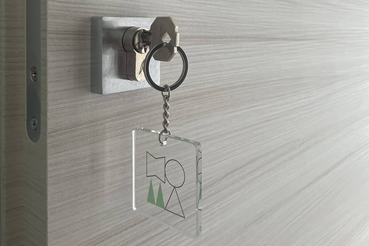 Una puerta con una cerradura y un llavero de diseño geométrico.
