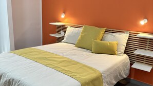 A neatly made bed with a white and yellow bedspread, two pillows, and a wooden headboard. - B&B HoMa (Naples)