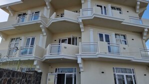 A multi-story building with balconies and large windows. - Doux Réveil (Cap Malheureux)