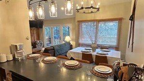 Una cocina con isla central, armarios de madera e iluminación colgante.