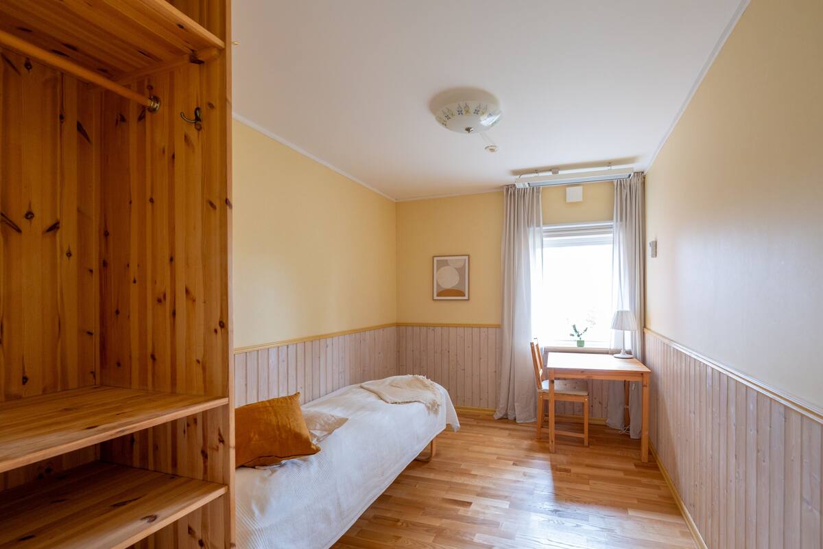 A room with a bed, a desk, and a chair.