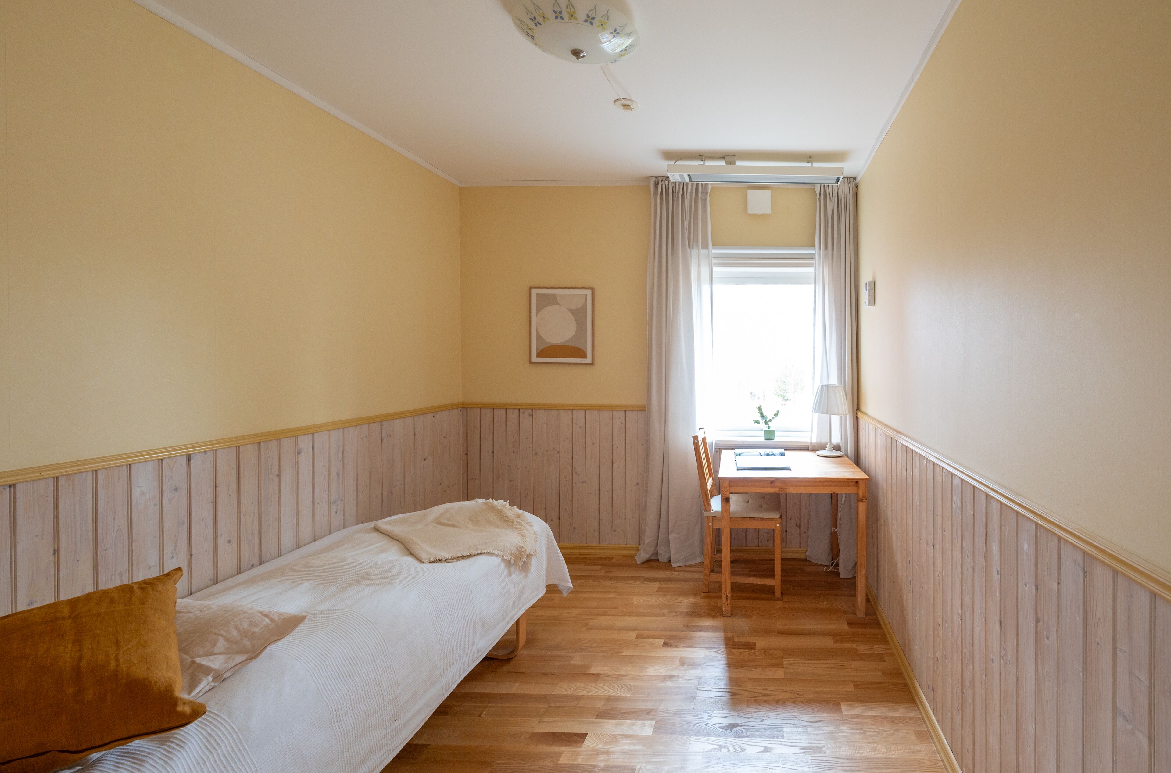 A room with a bed, a desk, and a chair.