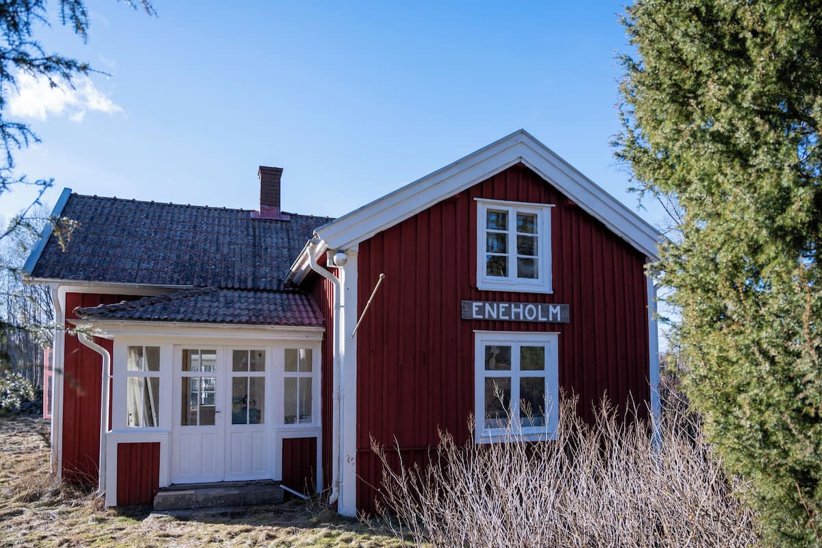 A red wooden building with a sign reading "ENEHOLM".