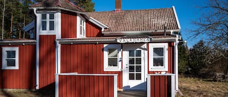 A red wooden building with a sign reading "VALKOMMEN".