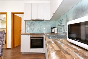A compact kitchen with a built-in oven, a microwave, and a backsplash with a grapevine design. - Villa Tereza - Four Bedroom Villa, Sleeps 8 (Prkos)