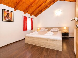 Ein Schlafzimmer mit einem hölzernen Bett, einem Nachttisch, zwei Wandleuchten und einem Gemälde an der Wand.