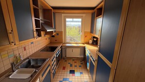 A compact kitchen with a window, a radiator, and a sink. - Apartment in Laatzen! contactless check-in 11P (Laatzen)