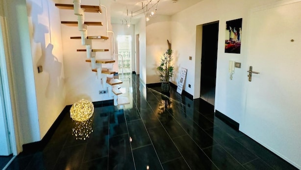 A modern interior with a spiral staircase, a polished black floor, and a minimalist design. - Apartment in Laatzen! contactless check-in 11P (Laatzen)