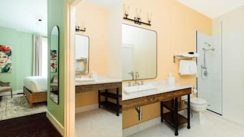 Un baño moderno con lavamanos doble, un espejo grande y ducha.