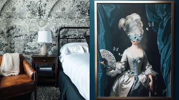 Un dormitorio con cama, mesita de noche y un retrato enmarcado.