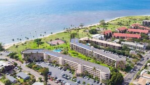 Eine Luftaufnahme eines Resorts mit mehreren Gebäuden, einem Parkplatz und einem Strand.