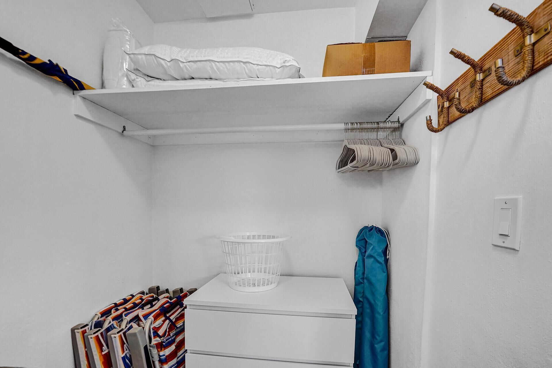 Une buanderie équipée d’un lave-linge blanc, d’un étendoir et d’un panier.