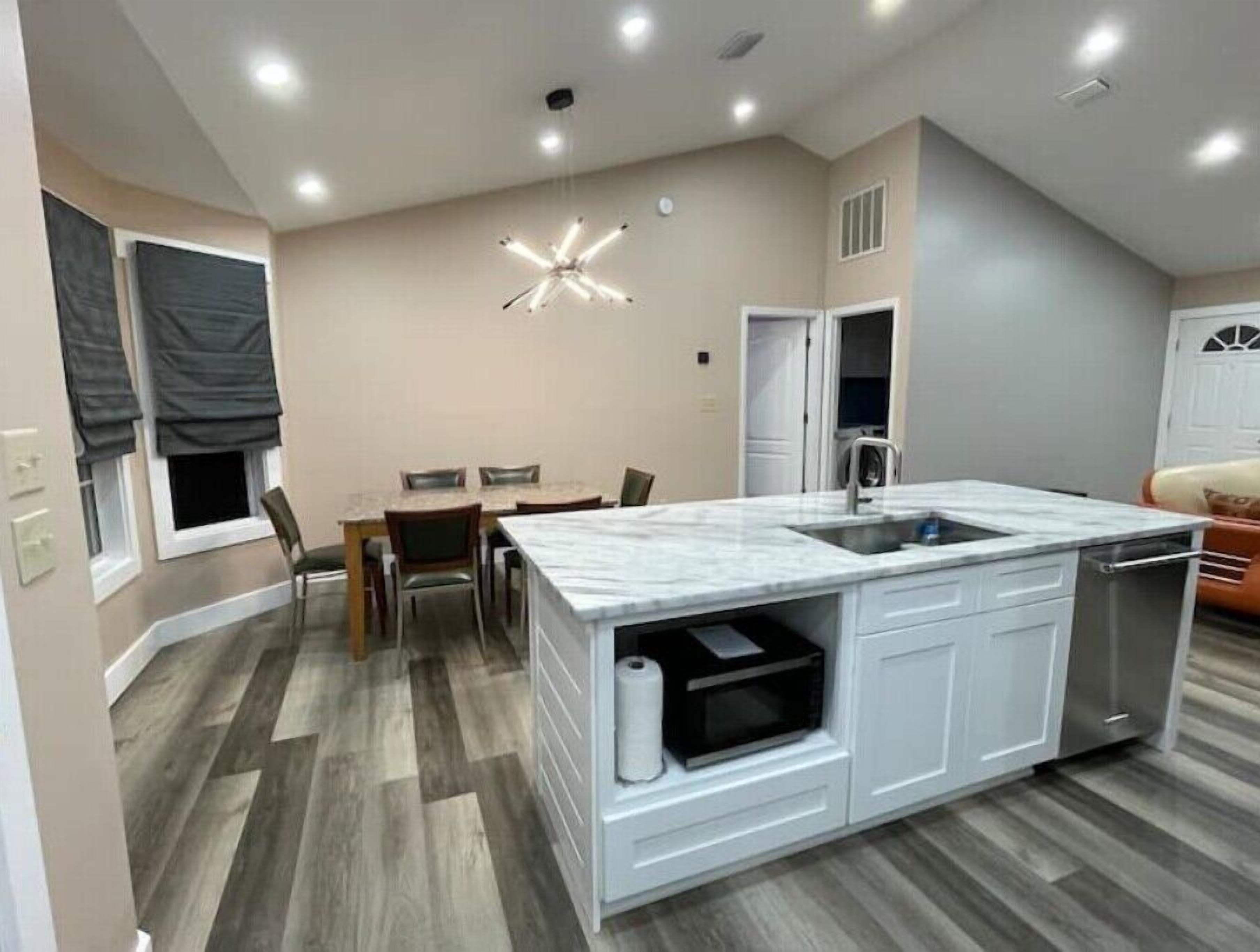 A modern kitchen with a marble countertop, white cabinetry, and a built-in oven.
