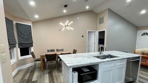 A modern kitchen with a marble countertop, white cabinetry, and a built-in oven. - Experience Tallahassee near FSU - Just a 12-min Drive (Tallahassee)
