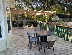 Enjoy dining or socializing on the covered deck with a pergola, surrounded by lush surroundings.