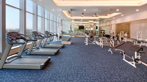 Ett modernt gym med löpband, styrketräningsmaskiner och träningsmattor.