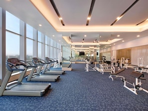 A modern gym with treadmills, weight machines, and exercise mats. - Grand Mercure Lampung (Bandar Lampung)