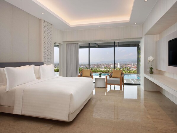 A modern hotel room with a large bed, a TV mounted on the wall, and a balcony with a pool view. - Grand Mercure Lampung (Bandar Lampung)