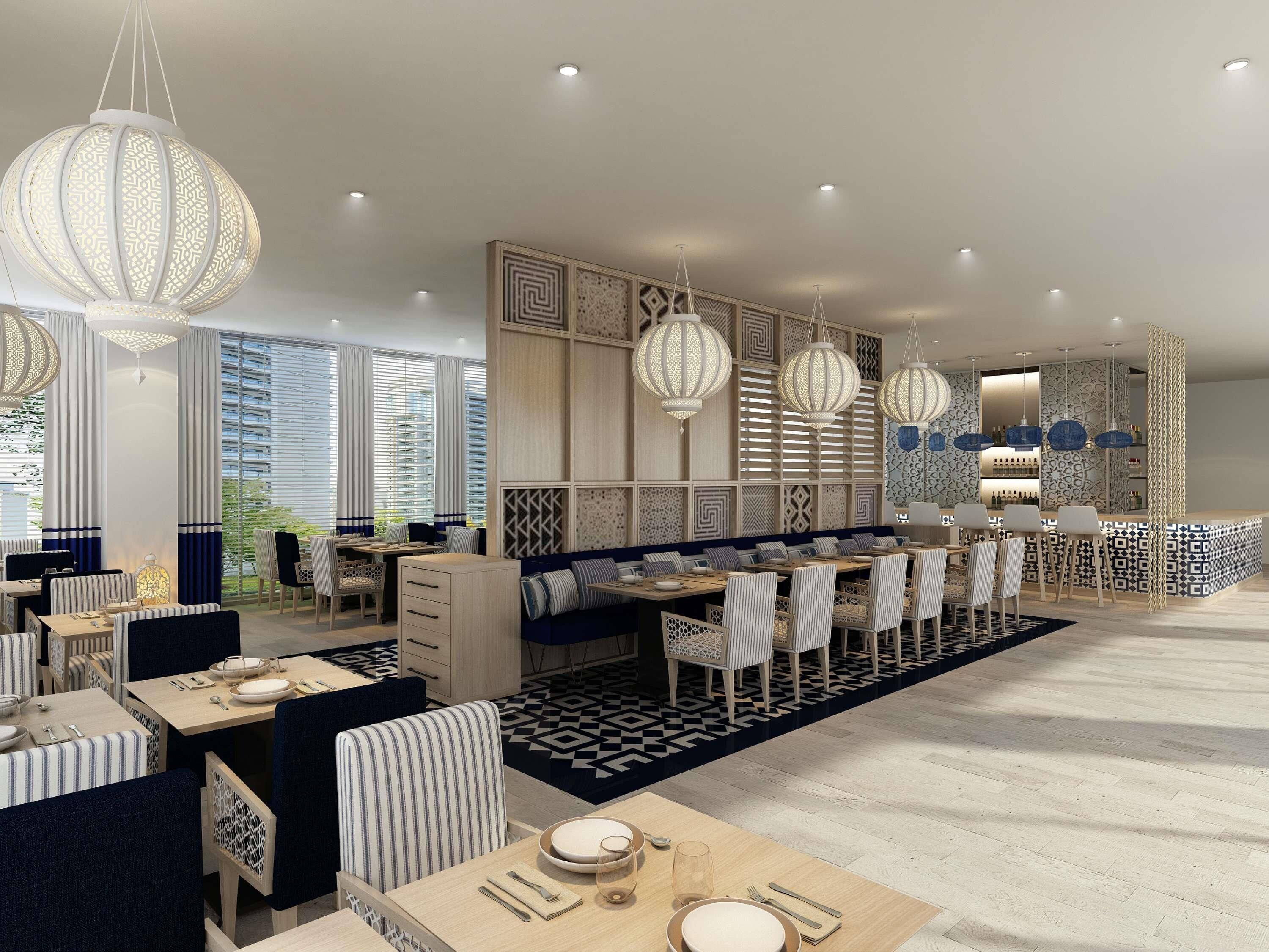 A modern dining area with multiple tables and chairs, decorative wall panels, and hanging lantern-style lights.