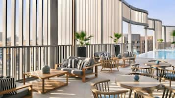 Eine Dachterrasse mit moderner Möbel, einem Pool und Blick auf die Stadt.