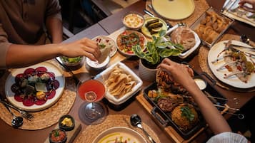 A dining table with various dishes, including a salad, a bowl of soup, and a plate of meat.