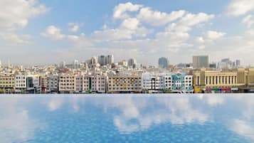 A cityscape with a clear sky and a swimming pool in the foreground.