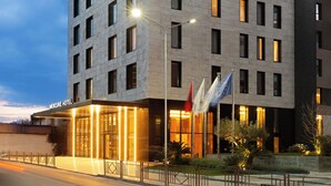 A modern hotel building with a prominent 'Mercure' sign, multiple floors, and a well-lit entrance. - Mercure Tirana (Tirana)