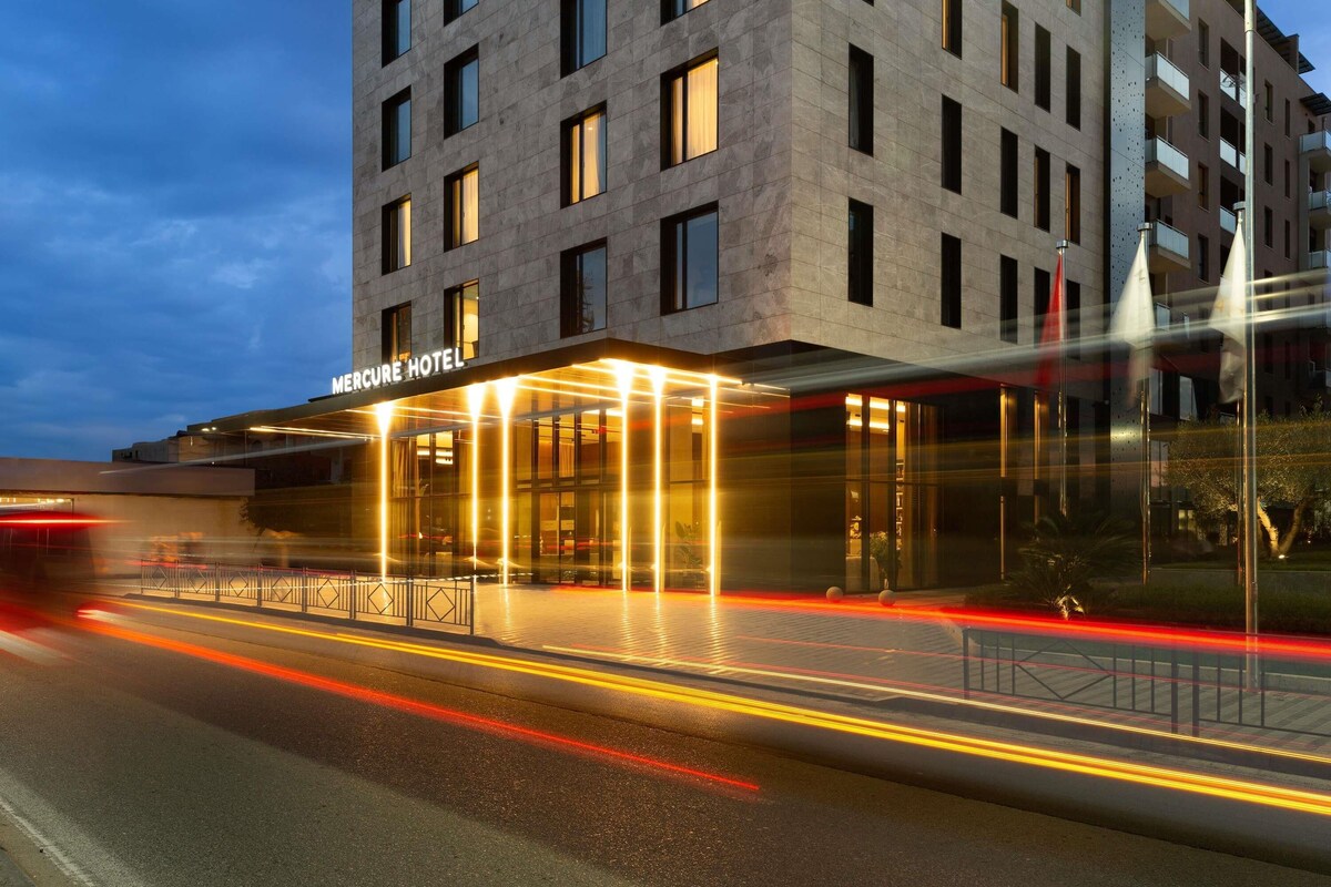 A modern hotel building with a prominent entrance and a well-lit facade.