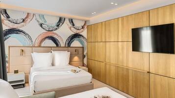 Una habitación de hotel moderna con una cama, mesita de noche y televisor de pantalla plana en la pared.