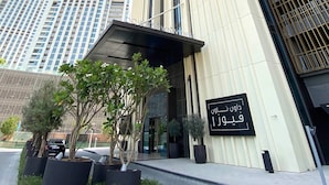 A modern building with a prominent vertical design, featuring a large entrance with a black signboard. - Silkhaus Near Dubai Mall Burj Khalifa (Dubai)