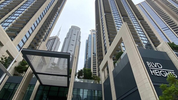 Ein modernes Hochhaus mit einer auffälligen 'BLVD HEIGHTS'-Beschilderung, das eine elegante Glasfassade und ein strukturiertes, geometrisches Design aufweist.