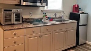 A compact kitchen with a microwave, toaster, and refrigerator. - Walla Walla Downtown Getaway (Walla Walla)