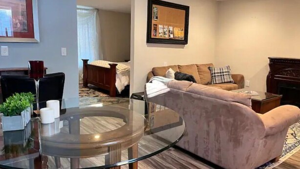 A living room with a glass-top coffee table, a sofa, a fireplace, and a framed picture on the wall. - Walla Walla Downtown Getaway (Walla Walla)