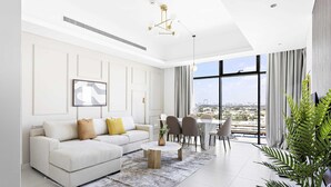A modern living room with a white sofa, a round coffee table, and a dining area with chairs. - Silkhaus Burj Khalifa Area Extra Single Room (Dubai)
