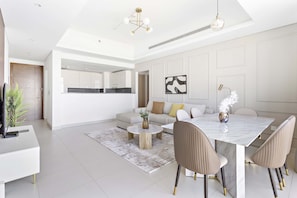 Uma sala de estar moderna com área de jantar, sofá, mesa de centro e um espelho grande.