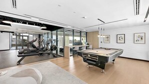 A modern indoor space with a pool table, exercise equipment, and a billiards table. - Silkhaus New Modern in JVC Convenient Location (Dubai)