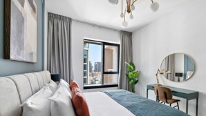 Une chambre d’hôtel moderne avec un grand lit, un bureau et une vue sur la ville.