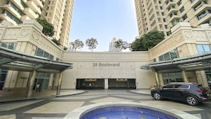 Un bâtiment moderne, avec une enseigne indiquant « 29, boulevard », et une cour intérieure dotée d’une piscine.