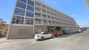 A multi-story hotel with a modern architectural design, featuring balconies and large windows. - Silkhaus New Large Furnished Studio in Luma21 (Dubai)