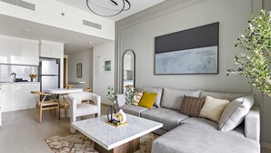 En moderne stue med en modulsofa, et sofabord og et spiseområde med stole og et bord.