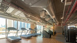 A gym with treadmills, elliptical machines, and weight equipment. - Silkhaus Luxurious New Tower With Pool Gym (Dubai)