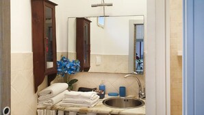 A bathroom with a sink, mirror, and towel rack. - Old Bridge Apartment (Firenze)