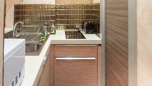 A compact kitchen with a dishwasher, a sink, and a countertop with kitchen appliances. - Old Bridge Apartment (Firenze)