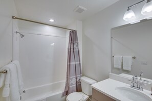Een badkamer met een bad, toilet en wastafel.