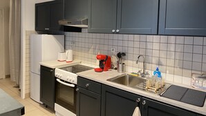 Una cocina moderna con gabinetes negros, un lavamanos de acero inoxidable y un horno empotrado.