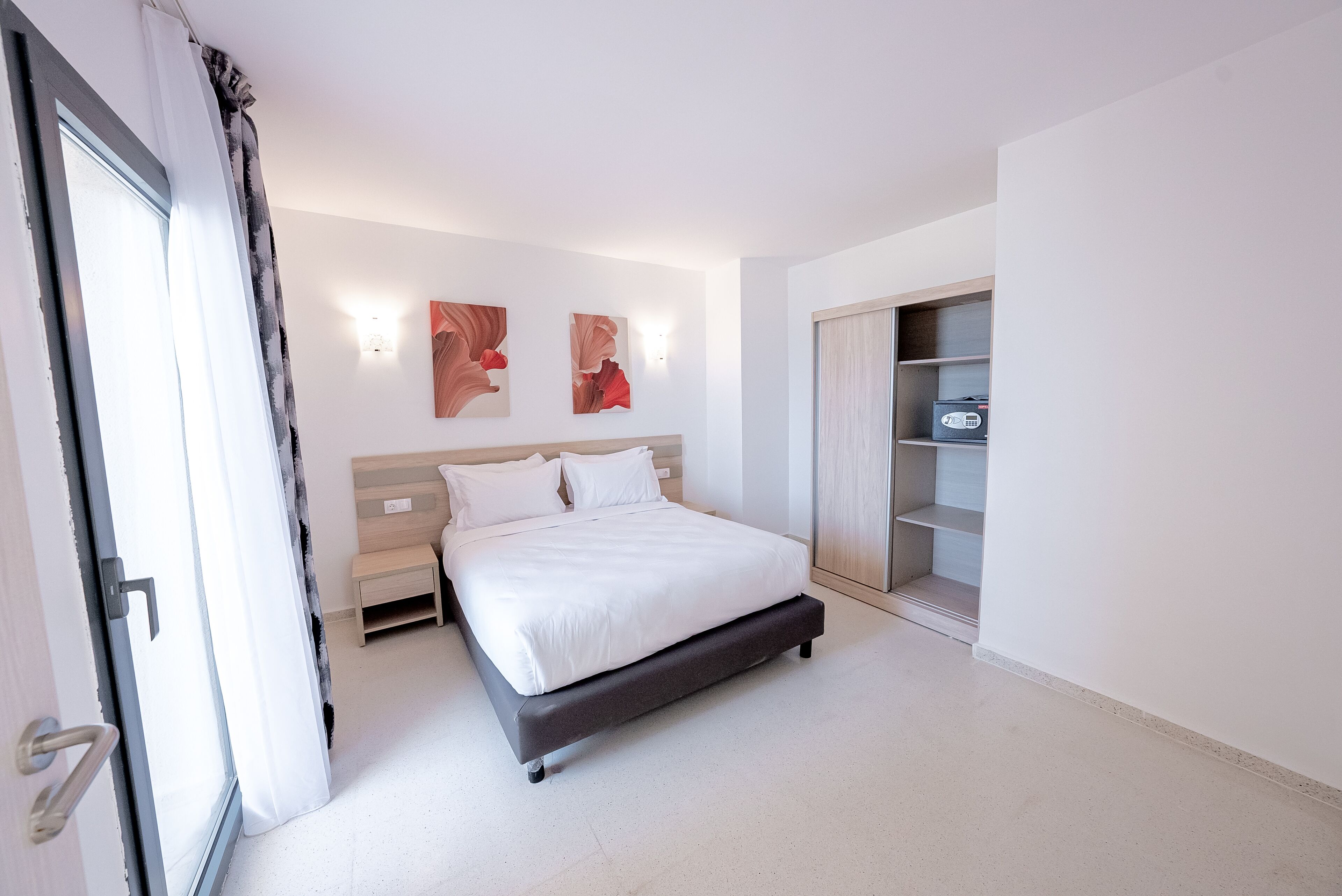 A modern bedroom with a bed, bedside tables, and a wardrobe.