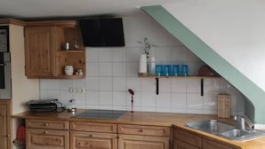 A kitchen with wooden cabinets, a microwave, a stove, and a sink.